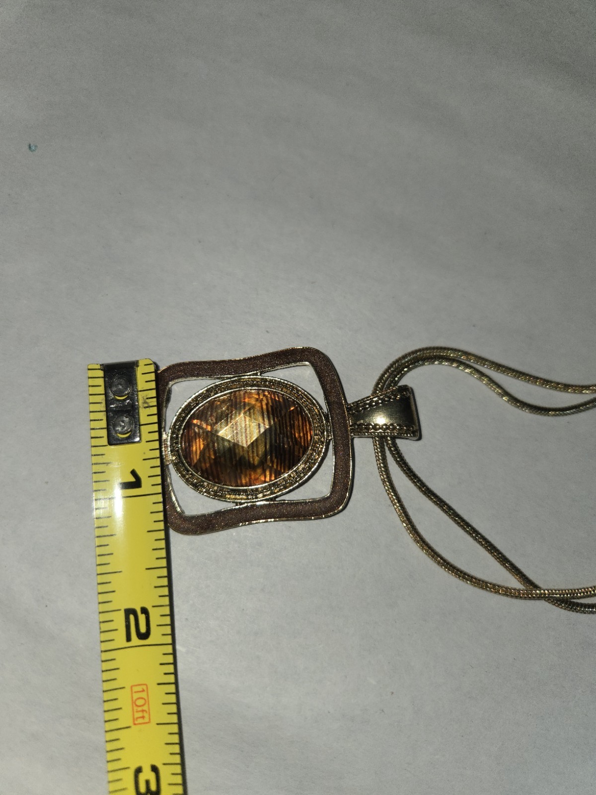 Origami Owl square pendant features a large, faceted oval topaz-colored crystal