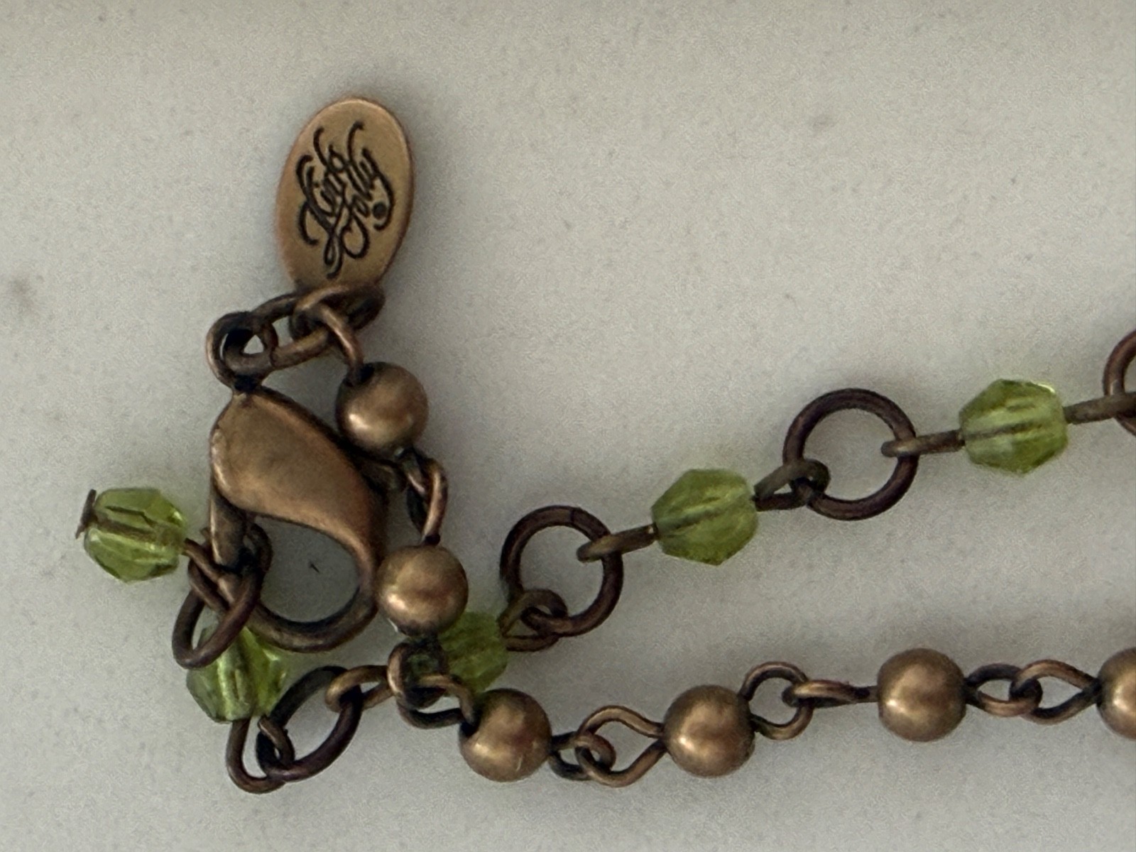 vintage Kirks Folly ornate cross pendant necklace, green crystals, bronze beaded