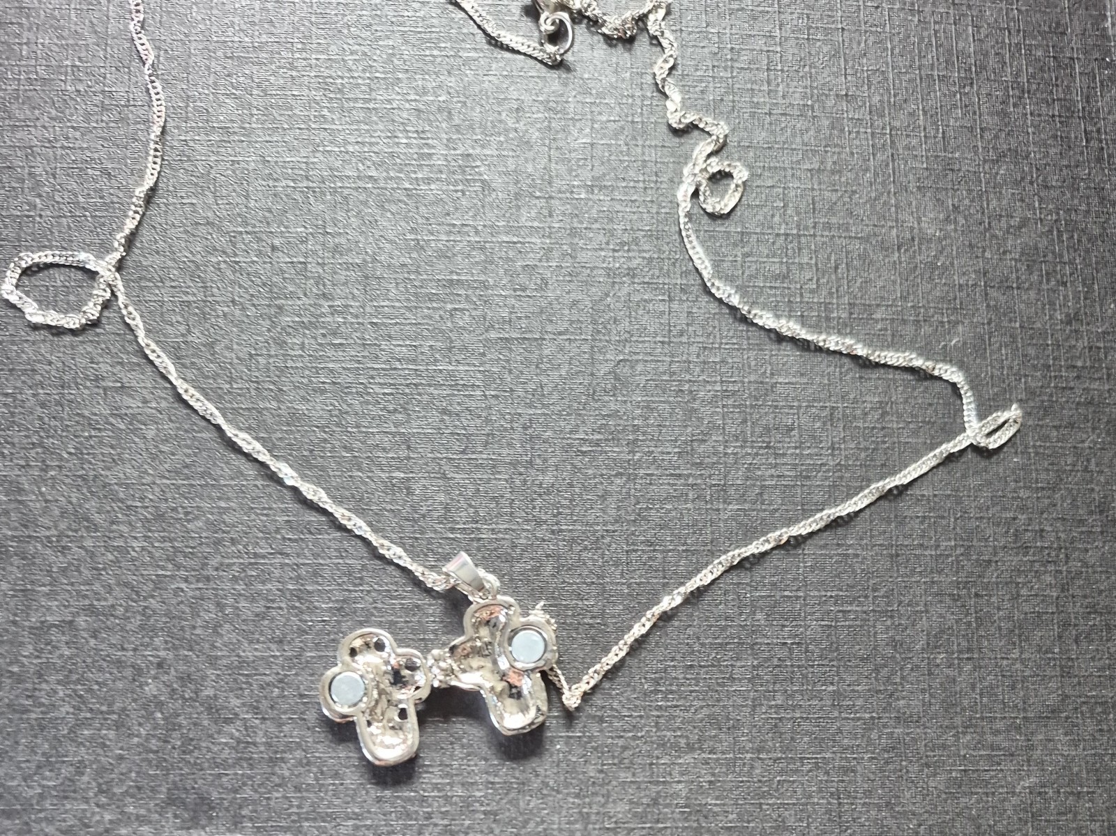 textured silver-tone chain and a cross pendant adorned with sparkling crystals