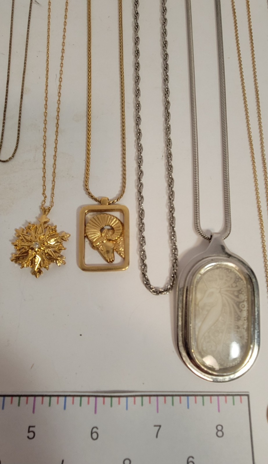 Lot of 11 metal chain necklaces, 6 with pendants. Various metals.