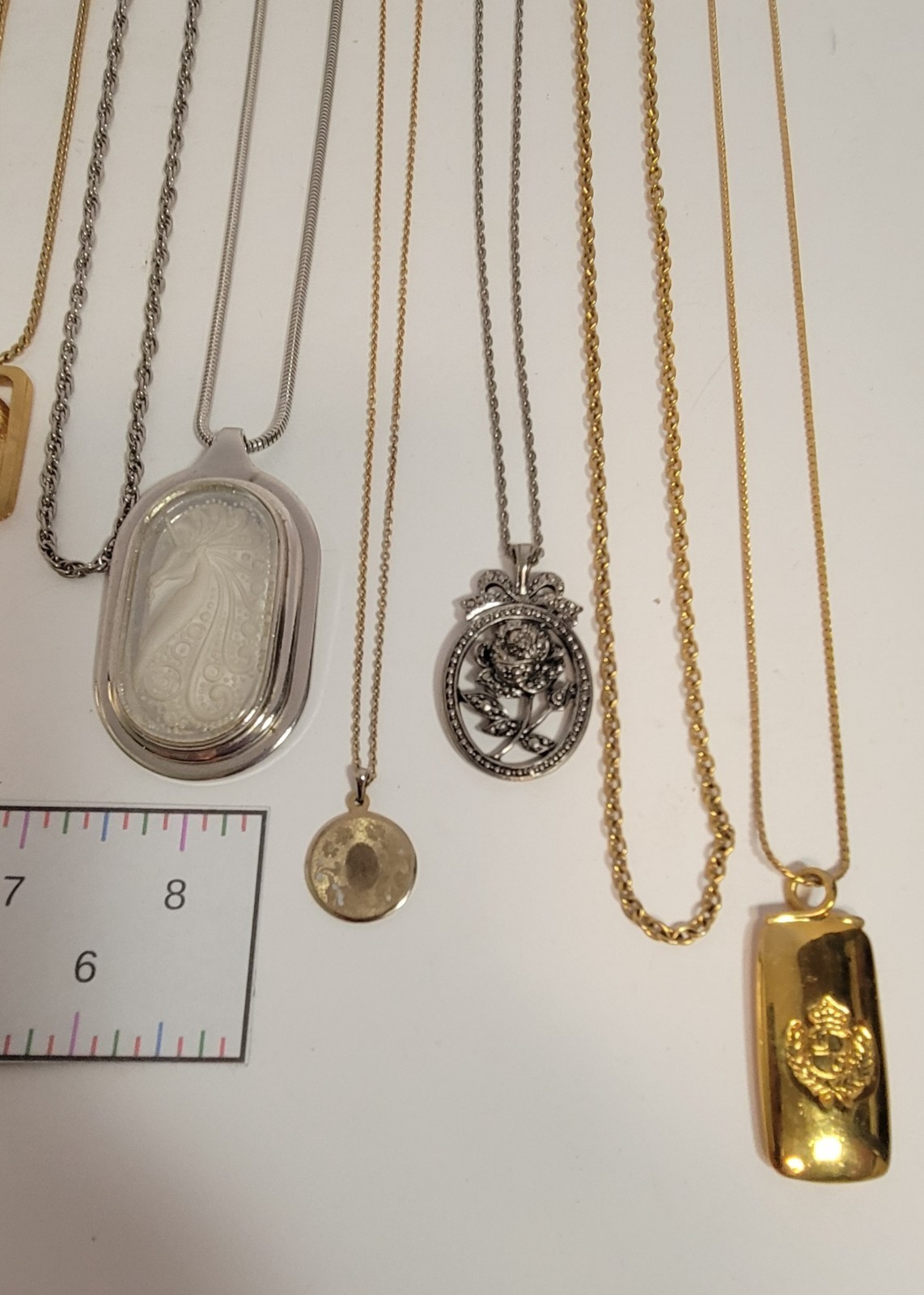 Lot of 11 metal chain necklaces, 6 with pendants. Various metals.