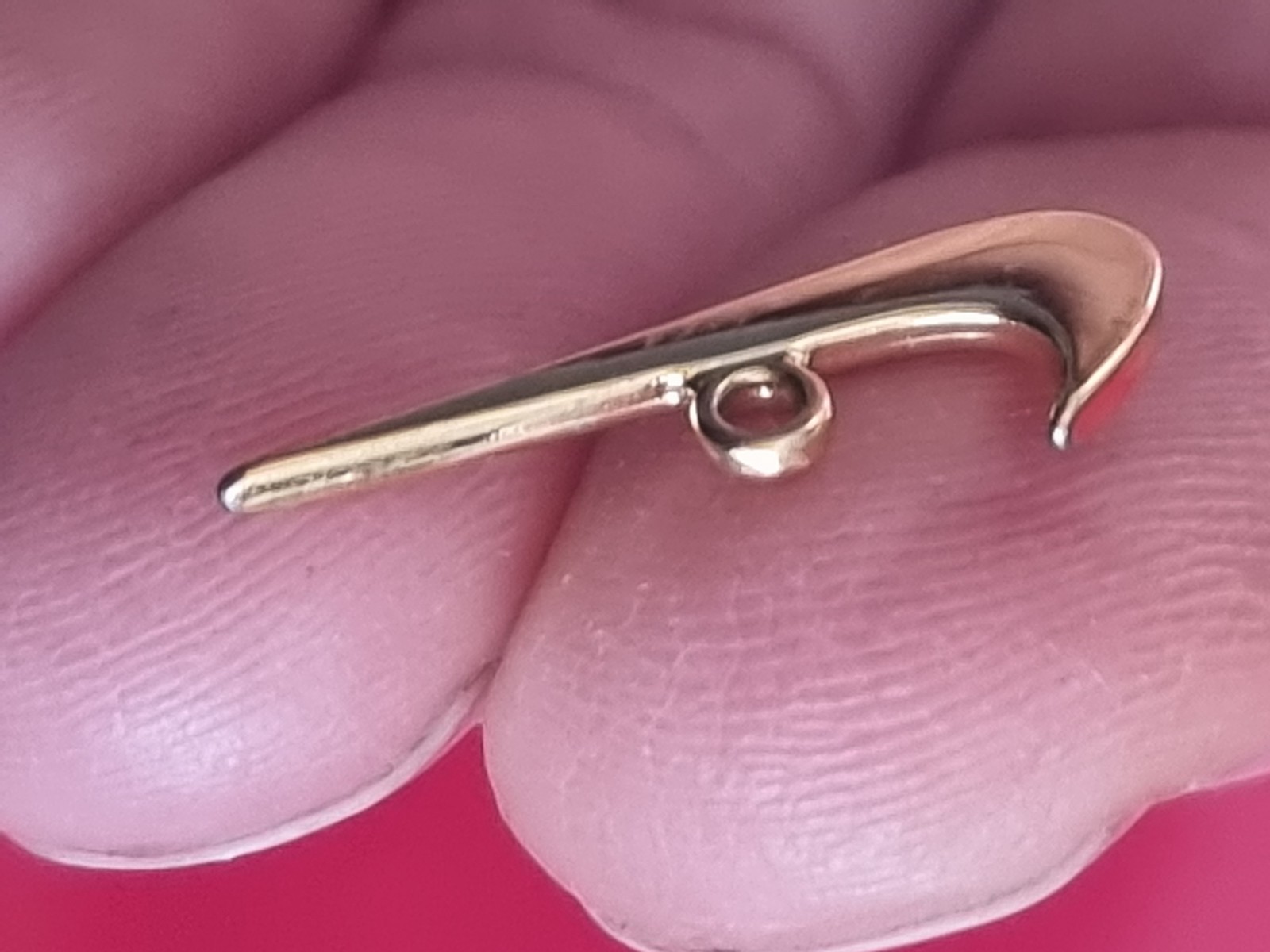 Small Nike tick pendant. Gold-coloured