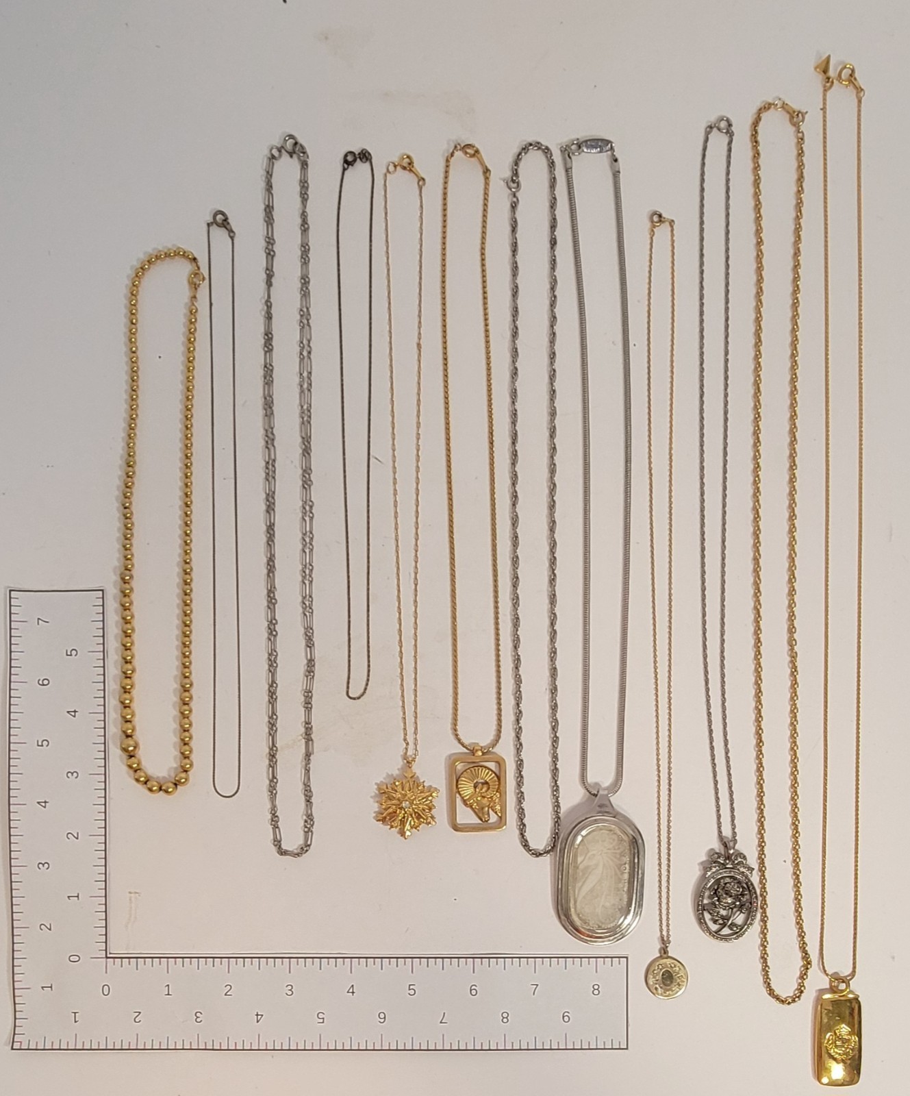 Lot of 11 metal chain necklaces, 6 with pendants. Various metals.