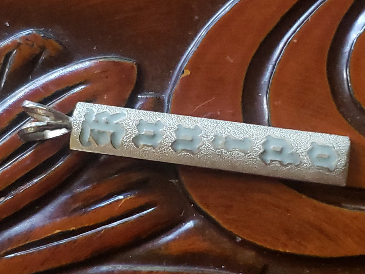 Vintage Silver Hawaiian Heirloom Kuuipo Gray Enamel Pendant Satin Sand Backgroun