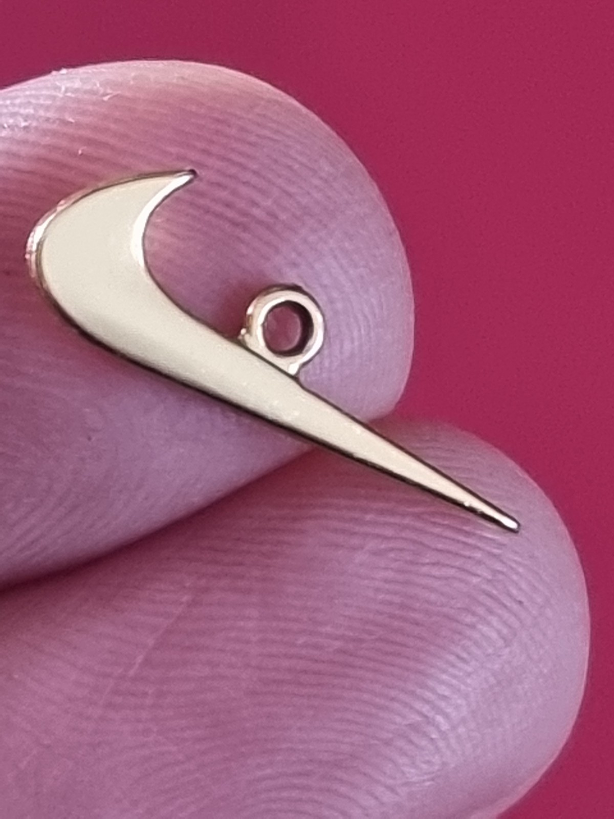 Small Nike tick pendant. Gold-coloured