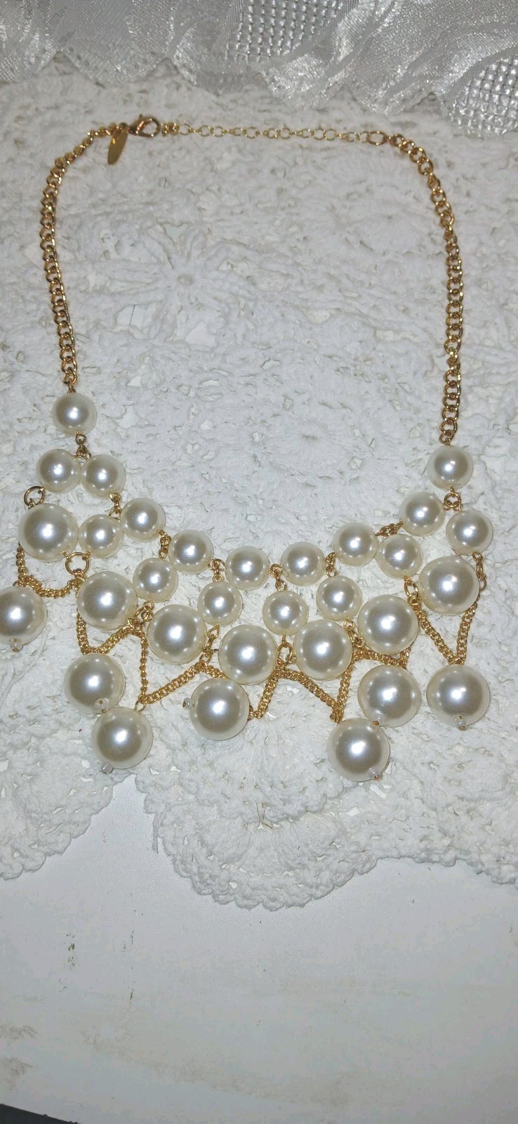 This gold-tone faux pearl cluster bib statement necklace features layered…