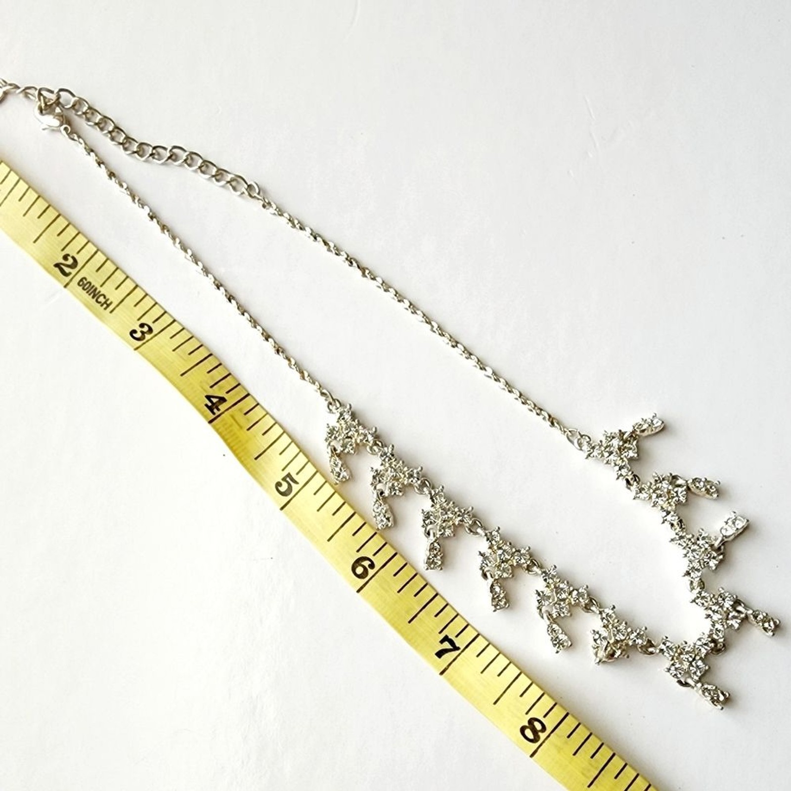 Silver tone necklace with prongs set white rhinestones round and square in shape
