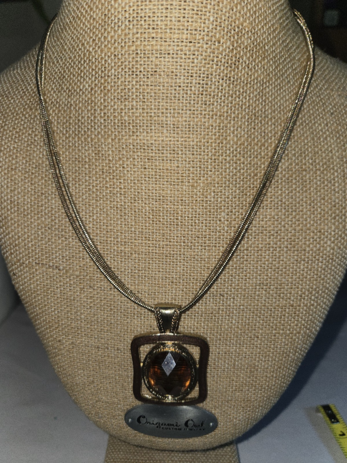 Origami Owl square pendant features a large, faceted oval topaz-colored crystal