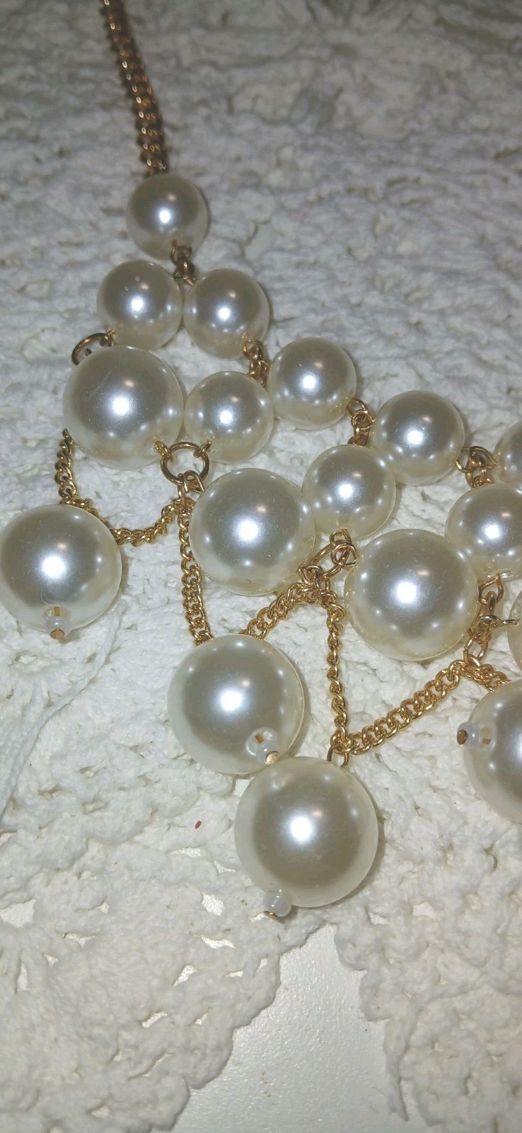This gold-tone faux pearl cluster bib statement necklace features layered…