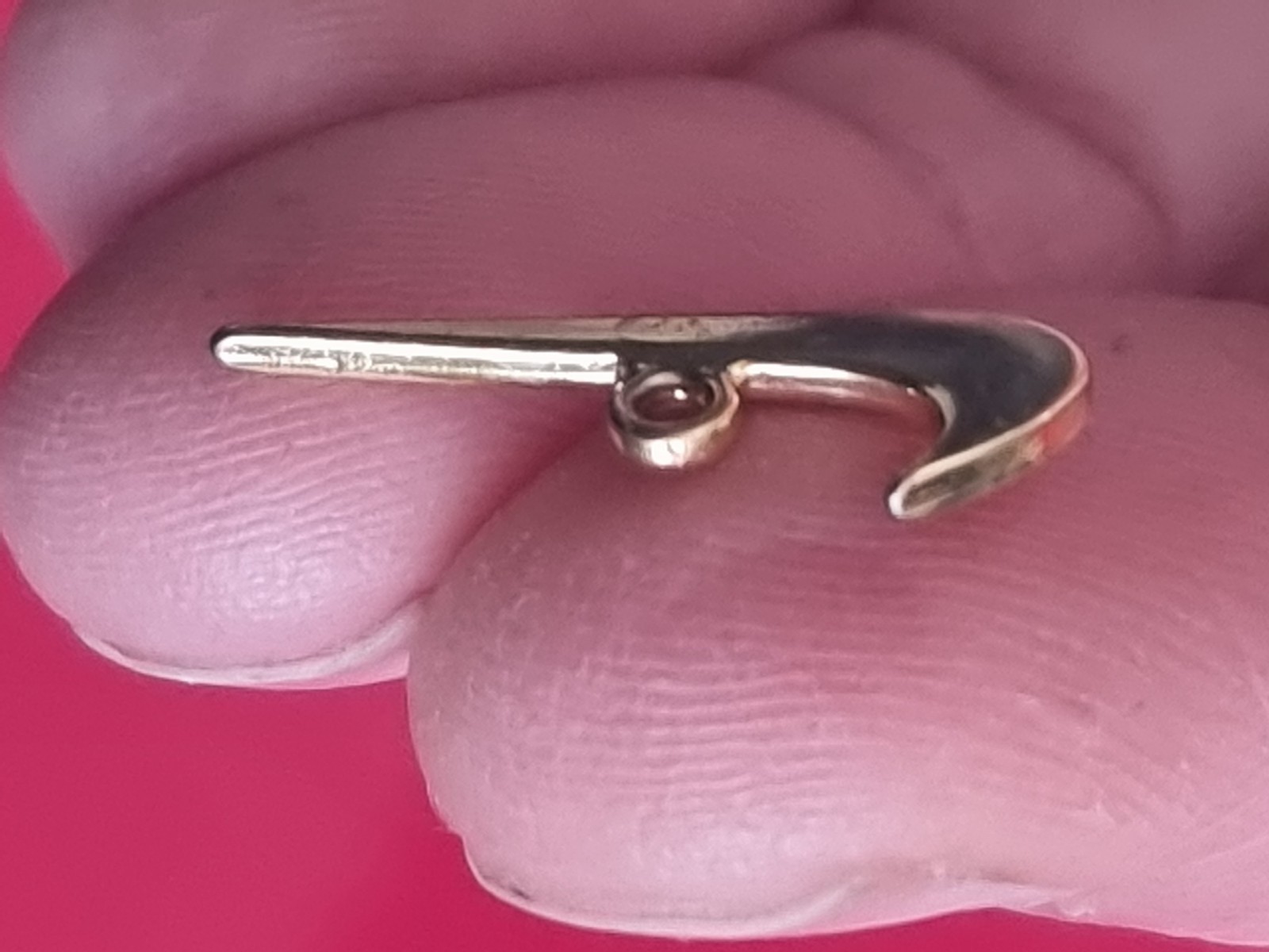 Small Nike tick pendant. Gold-coloured