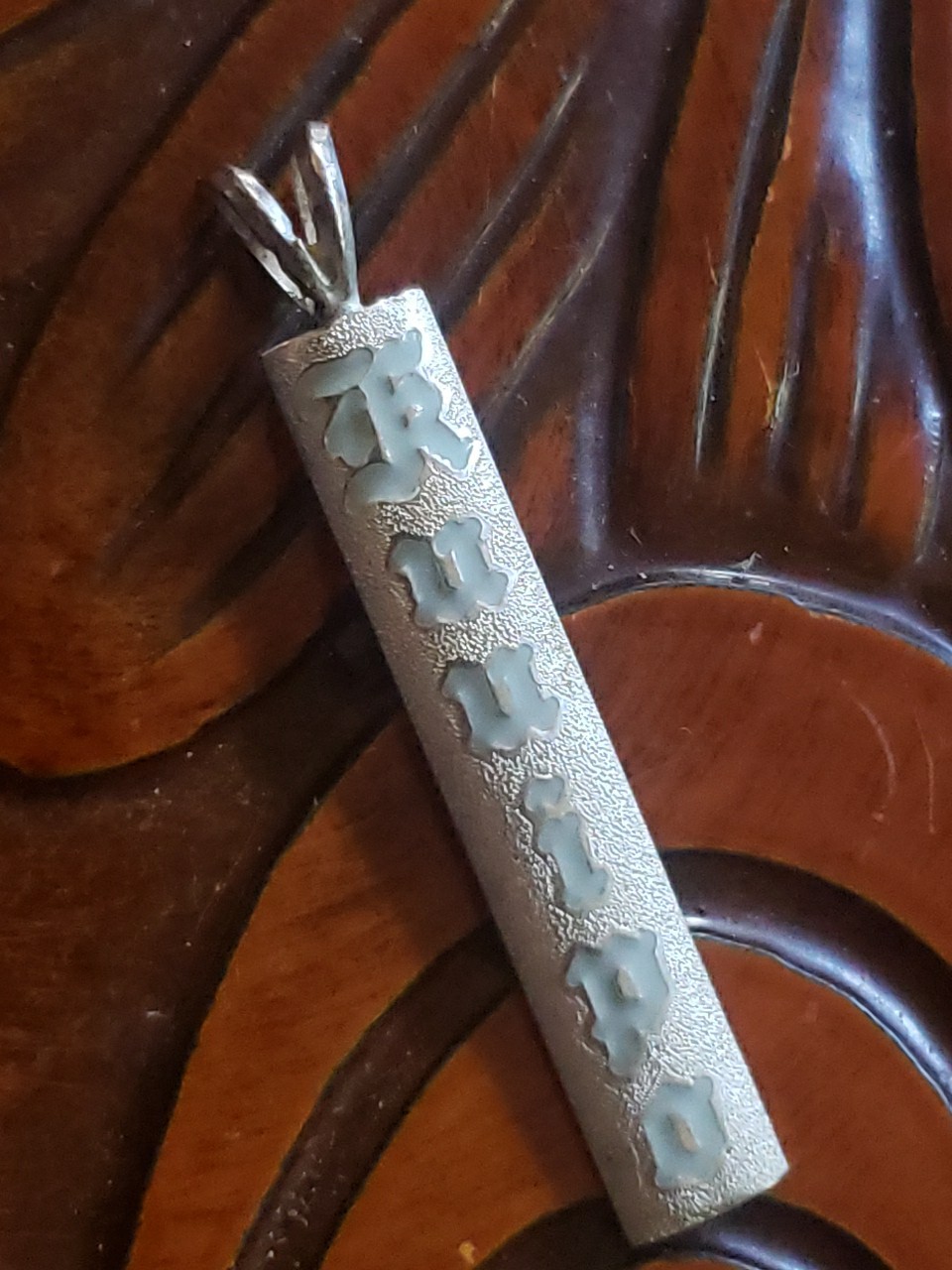 Vintage Silver Hawaiian Heirloom Kuuipo Gray Enamel Pendant Satin Sand Backgroun