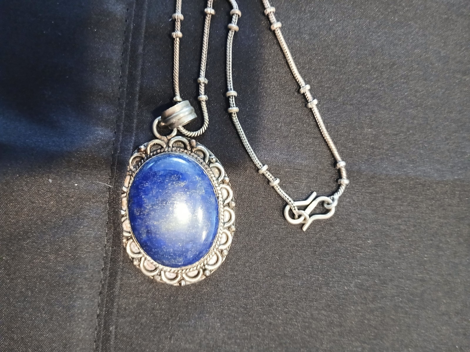 A lapis lazuli or saphire necklace with a metal necklace and metal edging