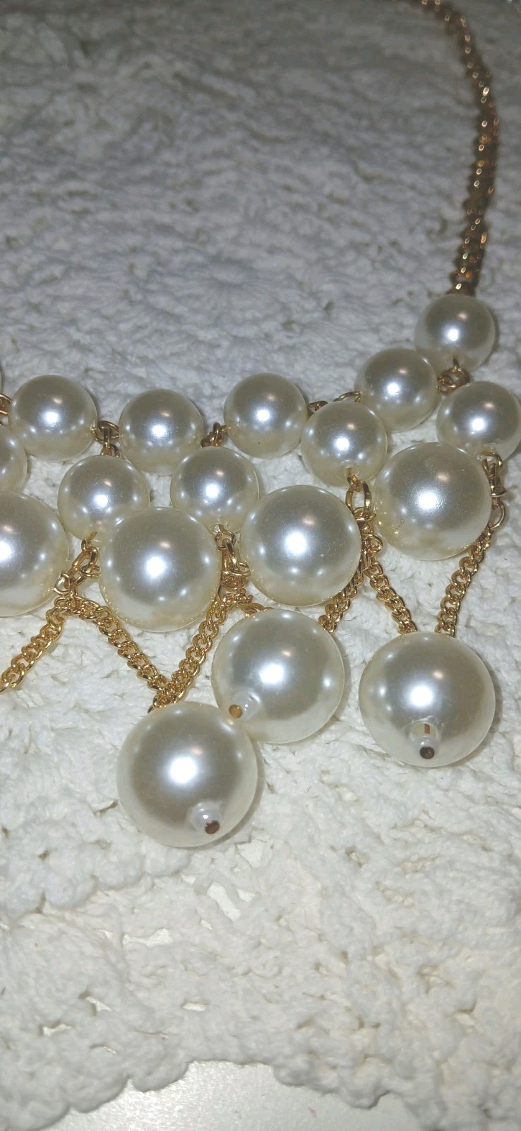 This gold-tone faux pearl cluster bib statement necklace features layered…